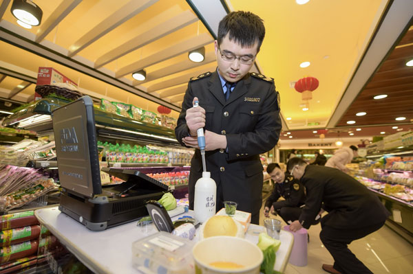 A safety inspector checks food products at a supermarket in Hefei, Anhui province, in February. (Photo/Xinhua)
