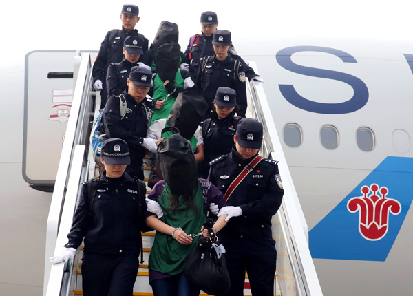Chinese telecom fraud suspects deported from Kenya get off a plane after arriving at the Beijing Capital International Airport in Beijing, capital of China, April 13, 2016. (Photo/Xinhua)