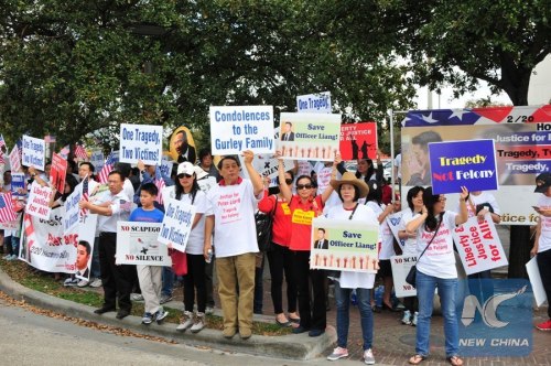 Demonstrators hold placards to demand justice for New York City police officer Peter Liang in a rally held in the city of Houston, the United States, Feb. 20, 2016. (Xinhua/Zhang Yongxing)