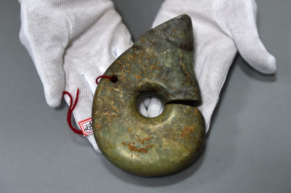 Police display a recovered jade dragon that is 5,000 to 6,000 years old.