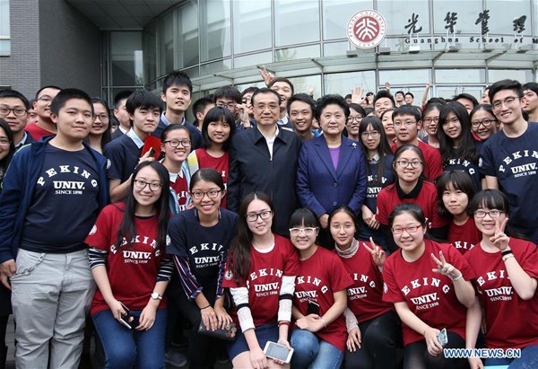 Chinese Premier Li Keqiang poses for a group picture with students of Guanghua School of Management at Peking University in Beijing, capital of China, April 15, 2016. Li on Friday visited Tsinghua and Peking, two prestigious universities in Beijing, to inspect about educational reform development and the implementation of innovation-driven development strategy. (Xinhua/Pang Xinglei)