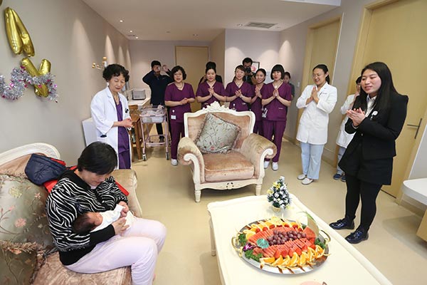 The staff of a high-end maternity hospital in Beijing hold a small party for the mother and her newborn baby.(Provided to China Daily)
