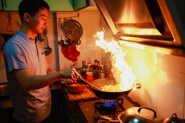Xiang Dongliang cooks a meal from GM food material at his home in Guangzhou, capital of Guangdong province. Photo by Liu Dongguang/for China Daily