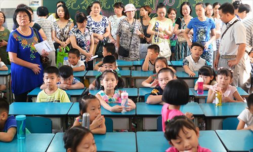 Many parents stand in the back of a first-grade classroom on the first day of school. They won't leave until the teacher asks them. (Photo/Courtesy of Jin Siliu)