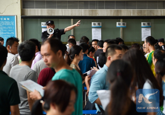 People wait in a real eatate transaction center in south China's Shenzhen city to get a reserve number, June 1, 2015. (Photo: Xinhua/Mao Siqian)