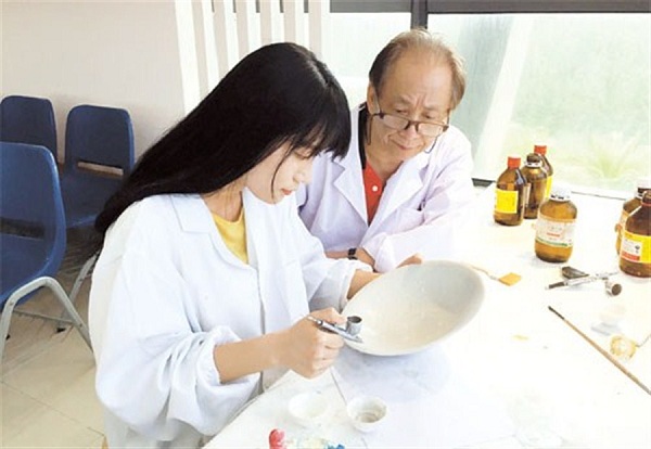 Jiang Daoyin (right) supervises his student, Zhou Yang, as she repairs one of the 800-year-old porcelain bowls from the Nanhai No 1.(Ti Gong)