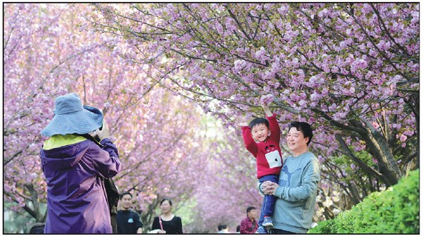 Tourists take photos on the campus of Xi'an Jiaotong University in Shaanxi province on March 31.Yuan Jingzhi / For China Daily