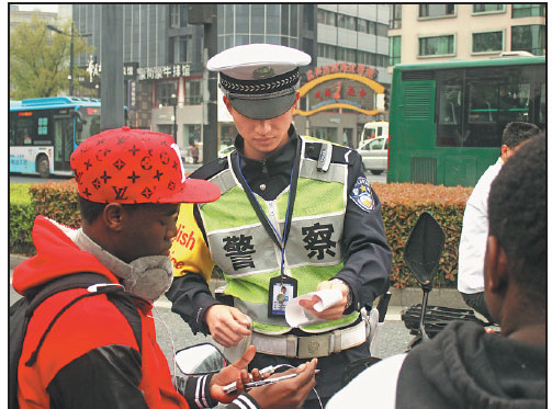 A member of the English Service Team of the traffic police brigade in Hangzhou's West Lake area provides assistance to foreign visitors.Photo Provided To China Daily