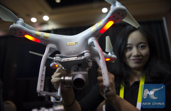 A staff member displays a DJI Innovations DJI Phantom 3 4K drone during the CES show in Las Vegas, the United States, Jan. 4, 2015. (Xinhua/Yang Lei)