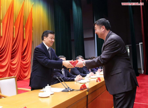 Liu Yunshan (L), president of the Party School of the Communist Party of China (CPC) Central Committee and a member of the Standing Committee of the Political Bureau of the CPC Central Committee, presents diplomas at the 2016 spring semester graduation ceremony of the Party School in Beijing, capital of China, April 28, 2016. (Xinhua/Liu Weibing) 
