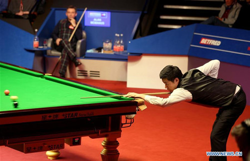 Ding Junhui (R) of China competes during the third session of the semifinal with Alan McManus of Scotland at the World Snooker Championship 2016 at the Crucible Theatre in Sheffield, England on April 29, 2016. Ding led 14-10 after the third session. Ding Junhui equalled the record for centuries scored by one player in a World Championship match as his sixth ton helped build a 14-10 lead over Alan McManus in an enthralling semifinal.The pair set a new record of nine tons in a World Championship match.(Photo: Xinhua/Han Yan)