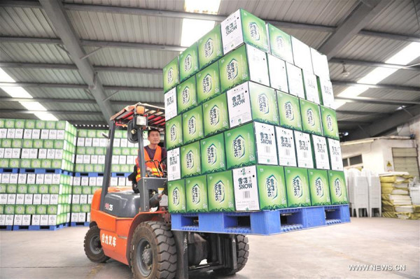 A worker transfers products at a brewery in Chengdu, capital of southwest China's Sichuan Province, August 1, 2015. China's economy grew by 6.9 percent in 2015. (Xinhua file photo/Liu Kun)