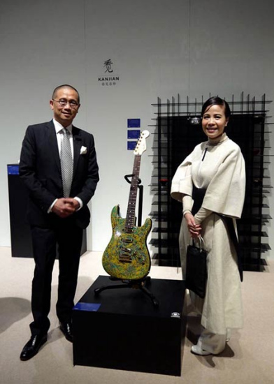 Musician Zhu Zheqin (right) and Kevin Ching, CEO of Sotheby's Asia, before the 'azure dragon Stratocaster' displayed in Hong Kong. Photos Provided To China Daily