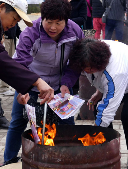 People in Beijing burn symbolic paper money outside a cemetery park as offerings to their deceased relatives on April 2, 2016 during the Tomb Sweeping Day holiday. (Photo/China News Service)