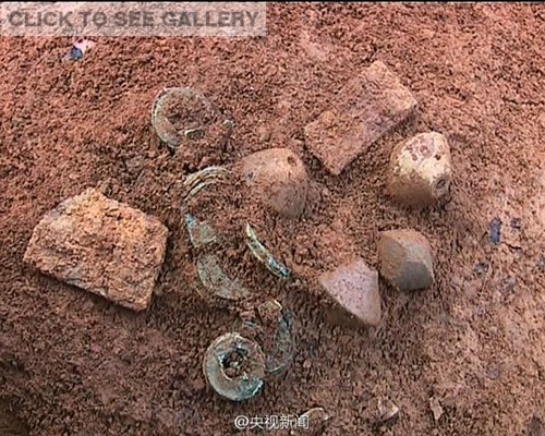 Relics are excavated from an ancient tomb built about 2,000 years ago in Zhongshan County, South China's Guangxi Zhuang Autonomous Region. A local farmer found the tomb while building a house. Pottery items, bronze coins, and thread-making devices are among the items found at the tomb site. (Photo/Weibo of CCTV)
