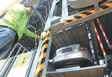 A technician demonstrates how to operate the parking machine at the new lot. Yang Kejia / China News Service