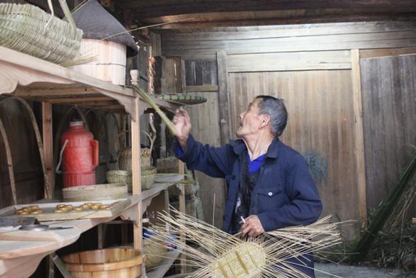 Hu picks bamboo splits from the shelf. (Photo by Zhou Xingzuo/chinadaily.com.cn)