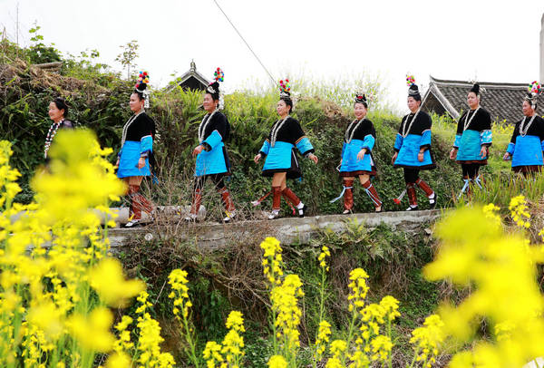 Women of the Dong ethnic group in Rongjiang county, Guizhou province, parade in their villages to pray for a good harvest in spring. [Photo provided to China Daily]