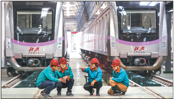Project manager Cui Hongjun (second from right) and three members of her maintenance team for Beijing Metro Line 13 prepare to examine subway trains at a workshop in Beijing's Changping district. Shen Bohan / Xinhua