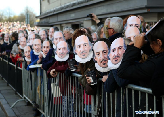 People put on their masks of William Shakespeare during the "Mask Moment" of the celebration marking the 400th anniversary of William Shakespeare's death in Stratford-upon-Avon, Britain on April 23, 2016. (Xinhua/Han Yan)