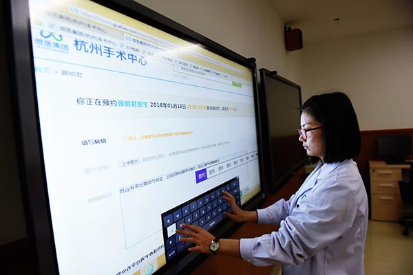 A member of medical staff operates big-screen online diagnostic equipment at a medical center in Hangzhou, capital of Zhejiang province. LONG WEI / FOR CHINA DAILY