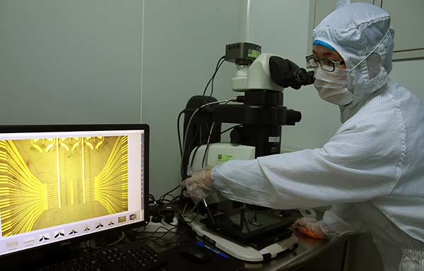 An engineer examines the microstructure of a biochip at the National Engineering Research Center for Beijing Biochip Technology in Beijing this month.Zou Hong / China Daily