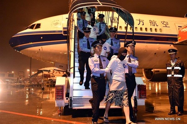 Chinese telecom fraud suspects are escorted off an aircraft by the police at Guangzhou Baiyun International Airport in Guangzhou, capital of south China's Guangdong Province, April 30, 2016. A total of 97 Chinese telecom fraud suspects, including 32 Taiwanese, were sent back from Malaysia under the escort of Chinese police on Saturday. The suspects are involved in more than 100 major transnational telecom frauds related to over 20 provincial areas in Chinese mainland. (Xinhua/Liang Xu)