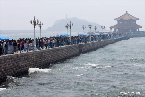 Tourists visit the Zhanqiao Pier in Qingdao, a coastal city in east China's Shandong Province, April 30, 2016. On the first day of the Labor Day Holiday, many tourists flocked to Qingdao. (Photo: Xinhua/Yin Mo) 