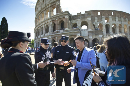 Chinese police Shu Jian (3rd R) and Sa Yiming (4th R) , together with two Italian police, check the documents of a Chinese tourist group outside the Colosseum in Rome, Italy, May 2, 2016. (Photo: Xinhua/Jin Yu)