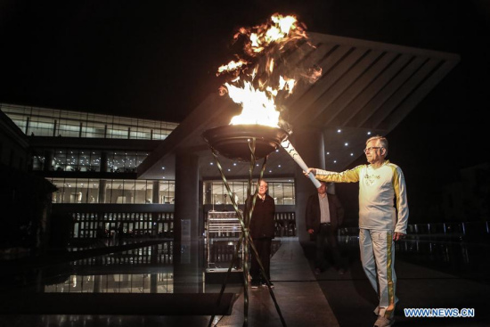 Hellenic Olympic Committee Secretary General Manolis Katsiadakis lights the cauldron in front of the Acropolis museum during the Olympic Flame torch relay for the 2016 Rio Summer Olympics in Athens, Greece, April 26, 2016. (Photo: Xinhua/Lefteris Partsalis)