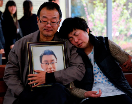 The parents of Wei Zexi, a computer science major at Xidian University in Shaanxi province who died of a rare form of cancer, wait outside a funeral home in Xianyang, Shaanxi, on April 13. (Photo: China Daily/Wan Jia)