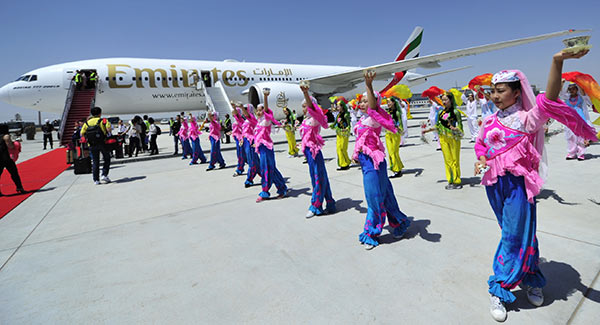 Dancers at Yinchuan Hedong Airport in the Ningxia Hui autonomous region welcome a Boeing 777 from the Middle East on Tuesday, when Emirates Airline launched its first direct flight between Dubai and Yinchuan, capital of Ningxia.(Zuo Mingyuan/For Chian Daily)