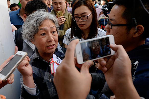 A woman identified only as Lu tells reporters at the Second Hospital of the Beijing Armed Police Corps in Beijing on Tuesday she is seeking are fund for therapy received by her husband, who had liver cancer and died in March last year. (Wei Xiaohao/China Daily)