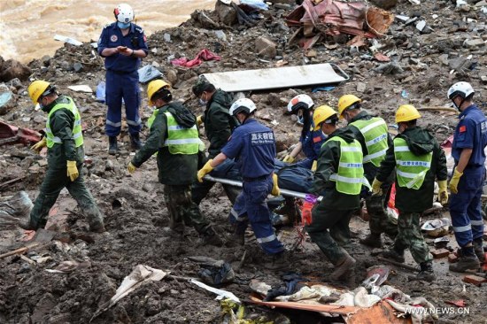Rescuers carry a body of victim at the landslide site in Taining County, southeast China's Fujian Province, May 9, 2016. Thirty-one bodies have been found and 7 people remain missing after a landslide hit Taining County in Fujian. (Photo: Xinhua/Zhang Guojun)