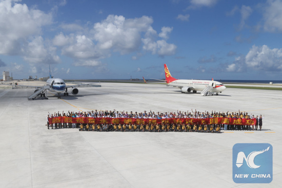 File photo: People pose for a group photo together after landing at the airfield on Yongshu Jiao in the Nansha Islands, Jan. 6, 2016. China successfully carried out test fights of two civilian aircraft on Jan. 6 on a newly-built airfield in the Nansha Islands of the South China Sea. (Xinhua file photo/Xing Guangli)