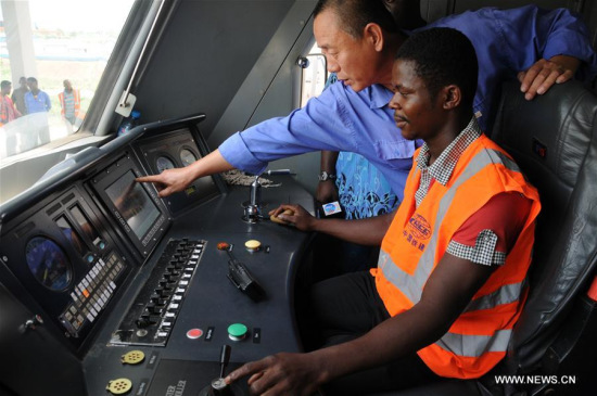 A Chinese train driver teaches a local worker on the train in Abuja, Nigeria on May 12, 2016. (Photo: Xinhua/Jiang Xintong)