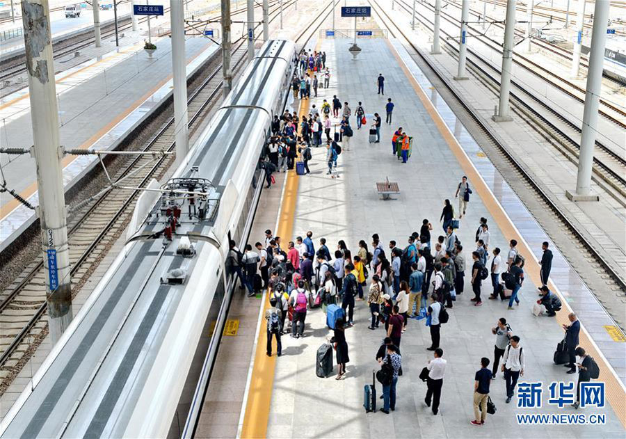 Passengers get on a bullet train at Shijiazhuang Rail Station, north China's Hebei province on May 15, 2016. (Photo/Xinhua)