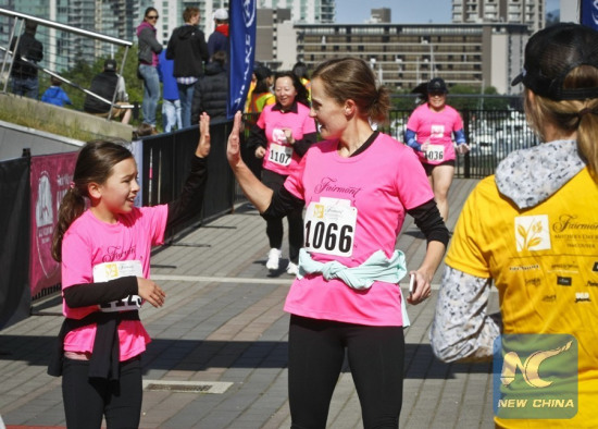 A mother celebrates with her daughter at the finish line during the Mother's Day CharityRun held in Vancouver, Canada, May 8, 2016. (Photo: Xinhua/Liang Sen)