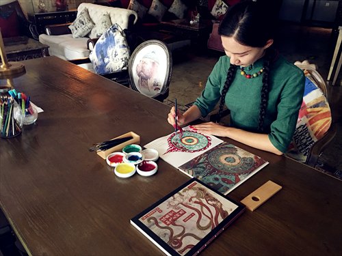 Yuan Xiaocha colors in a page from Coloring for Dunhuang Frescoes (Photo/Courtesy of Yuan Xiaocha)
