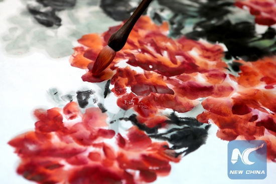 Ink wash painter Tian Shelang works on a painting in his studio in Hangzhou, capital of east China's Zhejiang Province, Dec. 9, 2012. (Photo: Xinhua/Zhang Chuanqi)