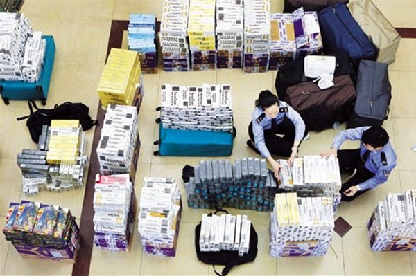 Customs officers at Shanghai Pudong International Airport are seen with some of the cigarettes said to be smuggled from Japan that were seized following a three-month investigation in conjunction with police and China Tobacco.(Wang Rongjiang)