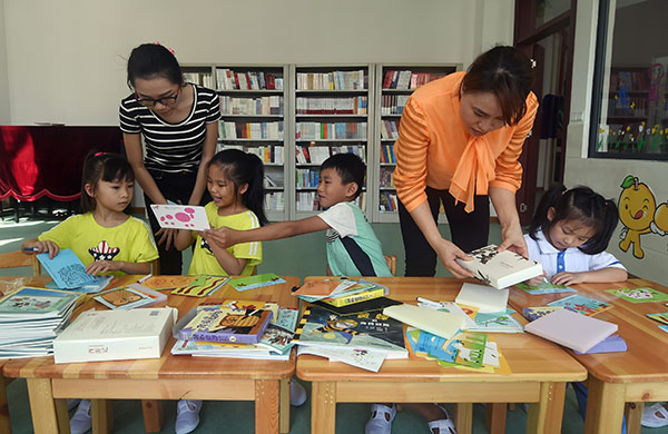 Teachers encourage students in a reading class at Yongxing School, Yongxing Island, where Sansha city is located. YANG GUANYU/XINHUA