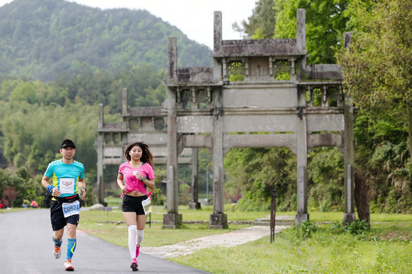 Runners pass Huizhou's classic paifang archways during the marathon. (Photo provided to China Daily)