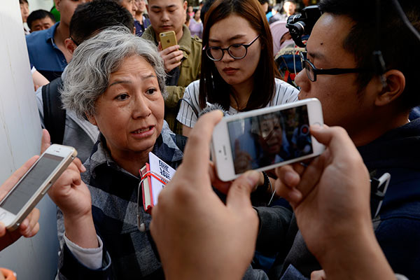 A woman identified only as Lu tells reporters at the Second Hospital of the Beijing Armed Police Corps in Beijing on Tuesday she is seeking are fund for therapy received by her husband, who had liver cancer and died in March last year. [Wei Xiaohao/China Daily]