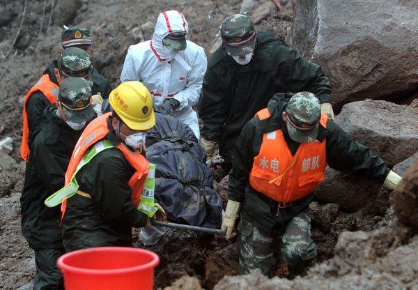 Rescuers remove bodies from the scene of a fatal landslide that hit a hydropower construction site in Fujian province on Sunday. XIA DAPENG/ FOR CHINA DAILY