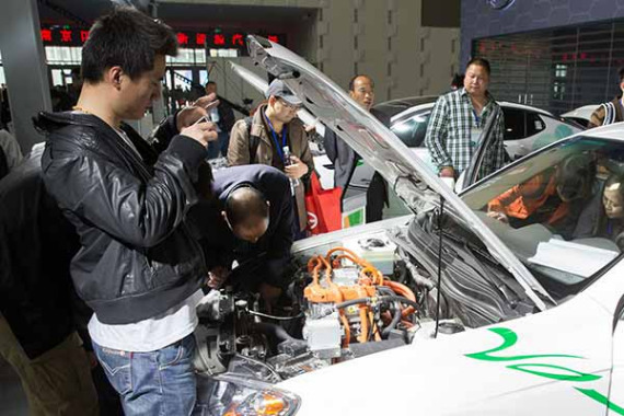Visitors check out a new energy vehicle powertrain in Nanjing city, Jiangsu province on April 17, 2016. (Su Yang / For China Daily)