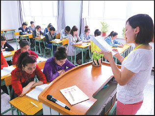 A student leads her classmates reciting a text in Mandarin at Hotan Teachers College on April 19. Cai Guodong / Xinhua