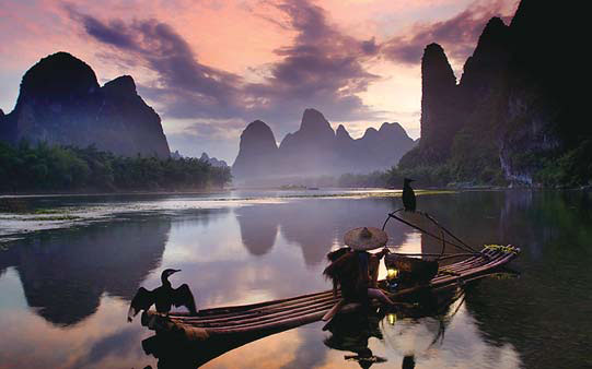 A fisherman works at night on Lijiang River in Guilin, Guangxi. (Photo by Liu Xianglong/For China Daily)