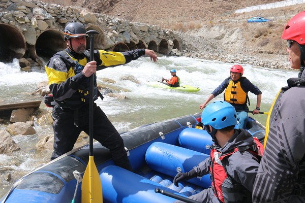 International Rafting Federation President Joe Willie Jones (left) takes a trial raft on a fast-flowing river in Yushu, Qinghai province during his visit in April. (Photo provided to chinadaily.com.cn)