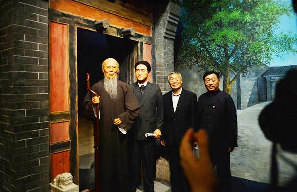 Xu Qingping (second right), son of Xu Beihong, and Lyu Zhangshen (right), director of National Museumof China, pose with wax figures of Qi Baishi (left) and Xu Beihong. Provided to China Daily